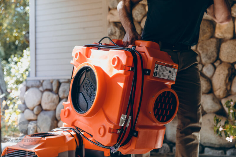 911 Restoration expert carries dryer equipment